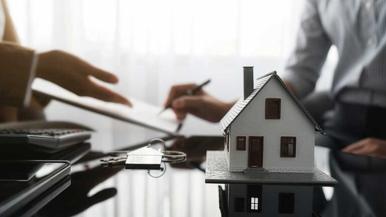 Homeowner reviewing insurance documents and comparing coverage details at a kitchen table